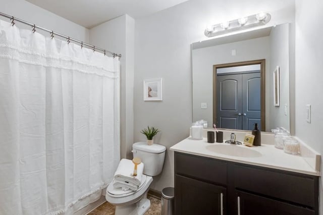 Toilet towels shower curtain vanity sink bathroom at The James Apartments Richmond in Richmond Student Accommodation