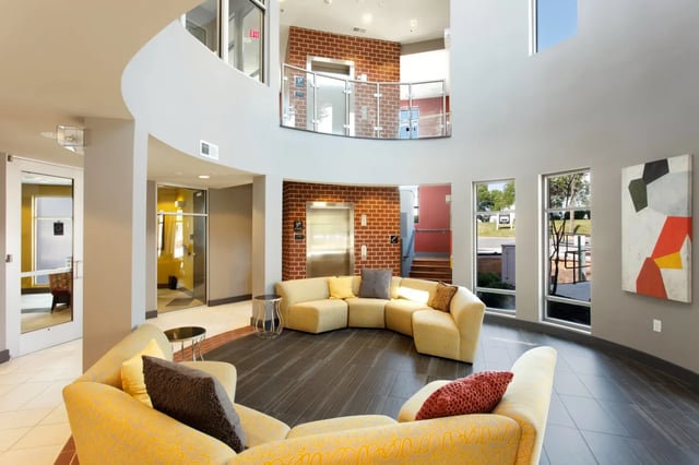 Yellow curved sofas with pillows lobby interior at The James Apartments Richmond in Richmond Student Accommodation