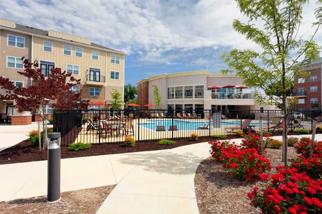 Apartment buildings with pool and red flowers exterior at The James Apartments Richmond in Richmond Student Accommodation