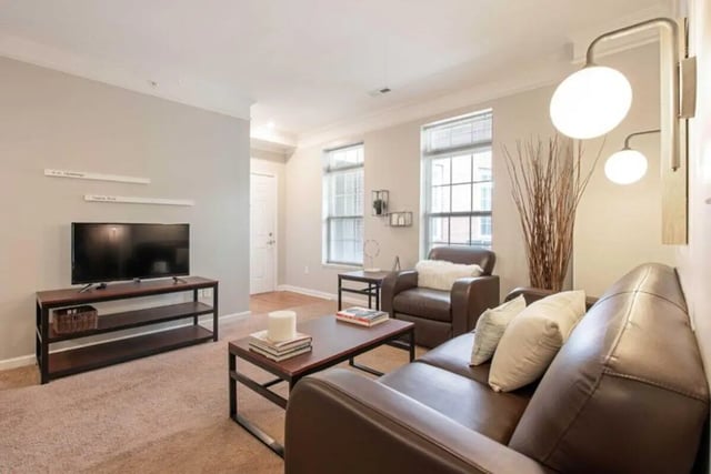 Brown leather sofas coffee table TV living room at University Edge-Cincinnati in Cincinnati Student Accommodation