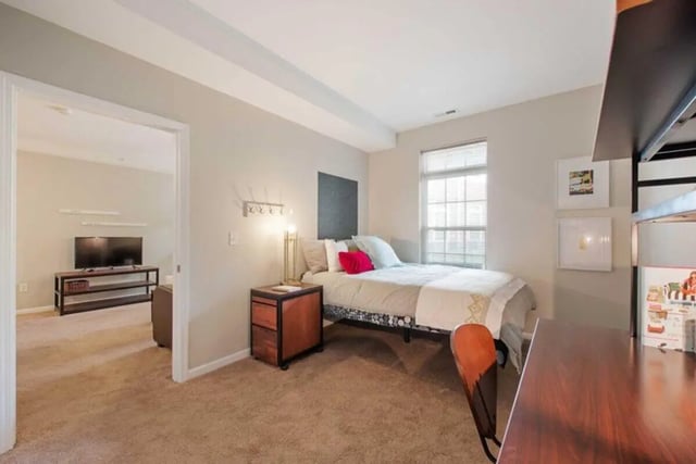 Bed nightstand desk and adjacent living area bedroom at University Edge-Cincinnati in Cincinnati Student Accommodation