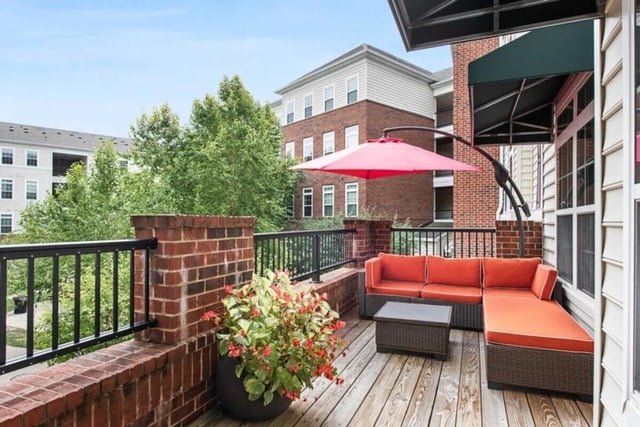 Orange sectional couch coffee table patio umbrella balcony at University Edge-Cincinnati in Cincinnati Student Accommodation