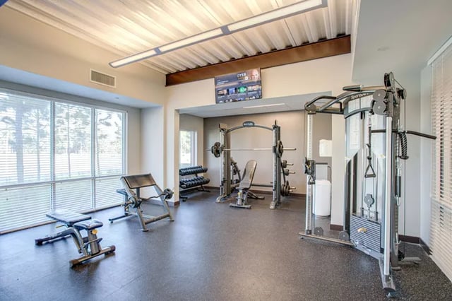 Gym equipment weights benches and machine room at Student Living at Florida Polytechnic University in Lakeland Student Accommodation