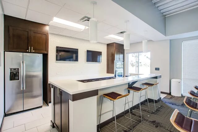 Stainless steel refrigerator with bar seating and TVs kitchen at Student Living at Florida Polytechnic University in Lakeland Student Accommodation