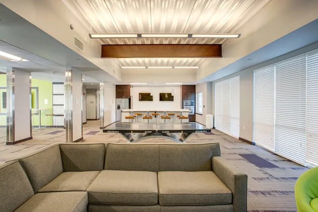 Sofa ping pong table kitchen lounge area at Student Living at Florida Polytechnic University in Lakeland Student Accommodation
