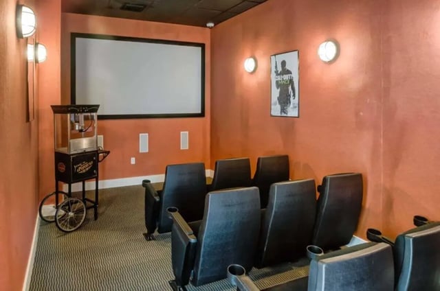 Theater room with projector screen popcorn cart and chairs movie room at West Run in Morgantown Student Accommodation