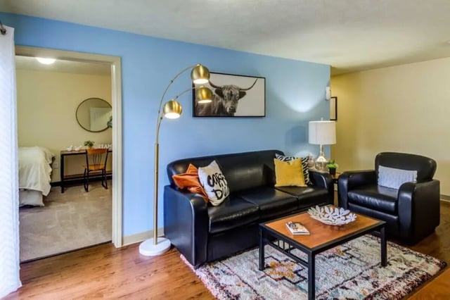 Black leather sofa and chair living room at West Run in Morgantown Student Accommodation