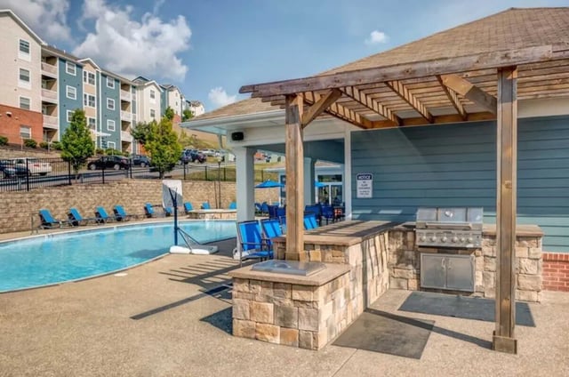 Pool with lounge chairs and outdoor grill area Exterior at West Run in Morgantown Student Accommodation