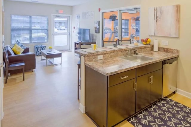 Sofa coffee table kitchen counter and sink living area at Irish Flats in South Bend Student Accommodation