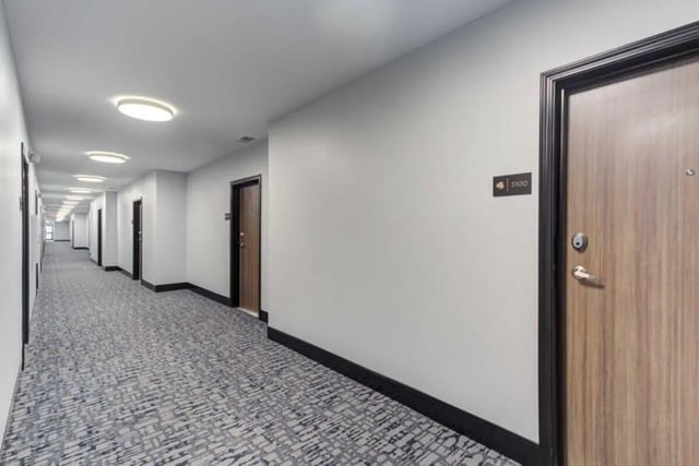 Hallway with patterned carpet and multiple doors hallway at Overlook at Notre Dame in South Bend Student Accommodation