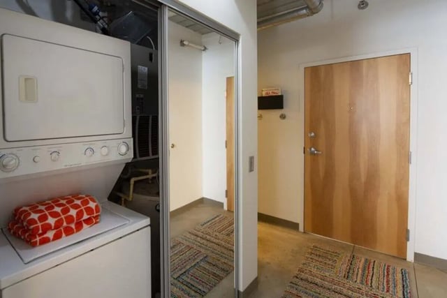 Stacked washer dryer and patterned blanket interior at The Abigail in Columbus Student Accommodation