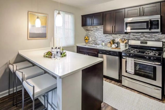 Island with stools stove and cabinets kitchen at The Flats at Douglas in Toledo Student Accommodation