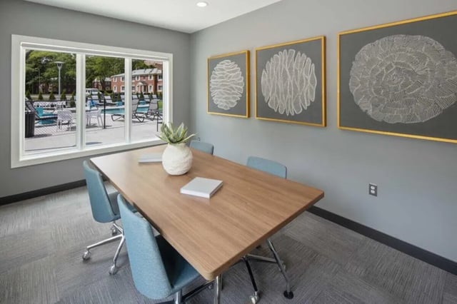 Conference table with chairs and artwork communal room at The Flats at Douglas in Toledo Student Accommodation