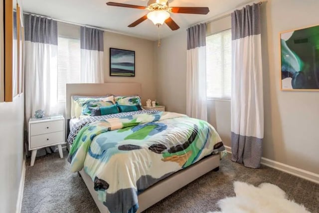 Bed with colorful bedding nightstand and artwork bedroom at The Flats at Douglas in Toledo Student Accommodation