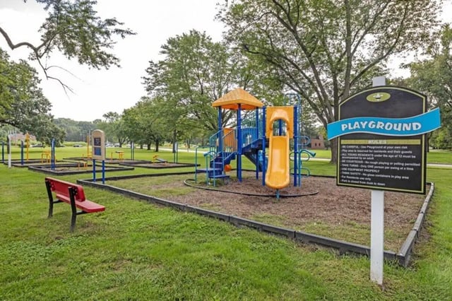Playground with slides swings and bench exterior at The Flats at Douglas in Toledo Student Accommodation