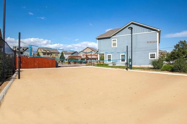 Sandy volleyball court with blue net and buildings exterior at The Outpost Fort Collins in Fort Collins Student Accommodation