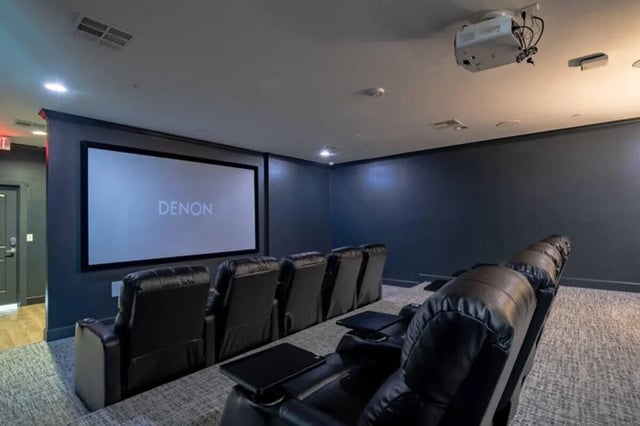 Theater seating and projector with screen cinema at The Outpost Fort Collins in Fort Collins Student Accommodation