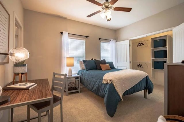 Bed desk ceiling fan and closet bedroom at The Outpost Fort Collins in Fort Collins Student Accommodation