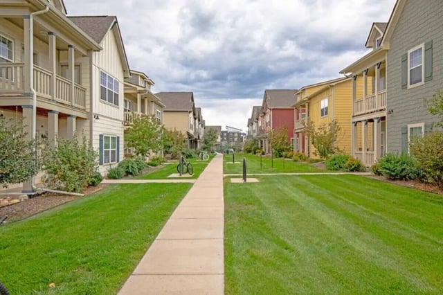 Colorful townhouses on green lawn exterior at The Outpost Fort Collins in Fort Collins Student Accommodation