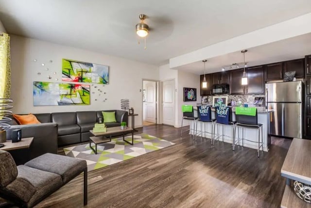Sofa coffee table artwork kitchen bar living room kitchen at The Reef in Fort Myers Student Accommodation