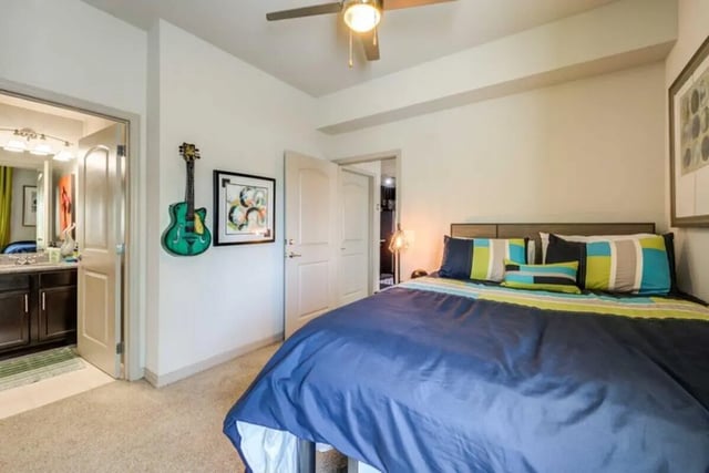 Bed with colorful pillows guitar on wall Bedroom at The Reef in Fort Myers Student Accommodation
