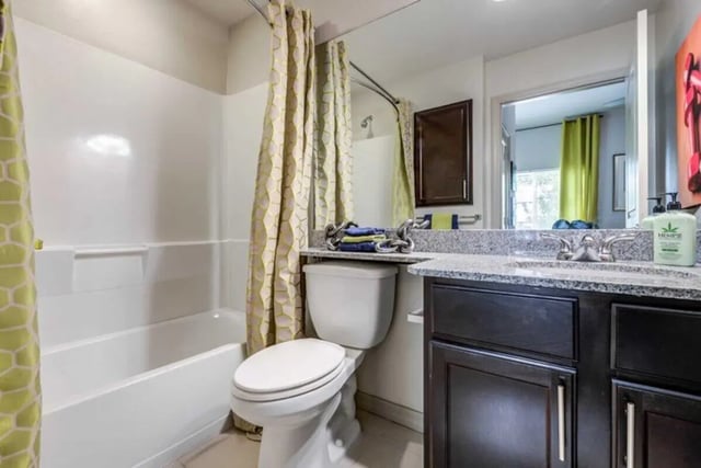 Toilet bathtub vanity and shower curtain bathroom at The Reef in Fort Myers Student Accommodation