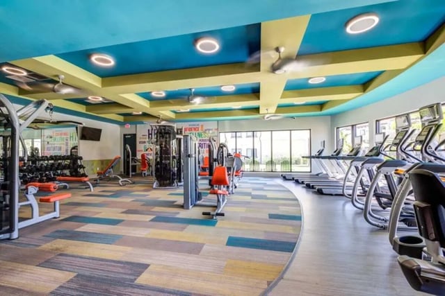 Weight machines treadmills and colorful flooring gym at The Reef in Fort Myers Student Accommodation