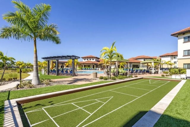 Shuffleboard court pool area with lounge chairs exterior at The Reef in Fort Myers Student Accommodation