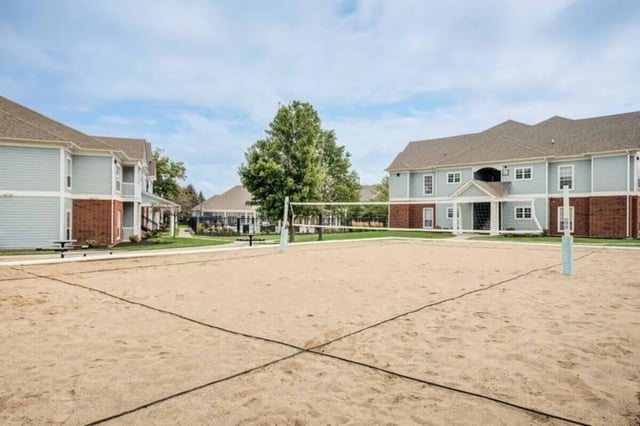 Sand volleyball court with apartment buildings exterior at The Lodge on the Trail in West Lafayette Student Accommodation