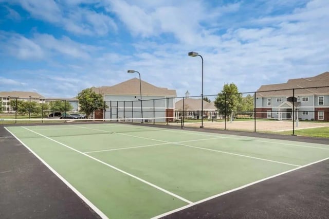 Green tennis court with buildings and trees exterior at The Lodge on the Trail in West Lafayette Student Accommodation