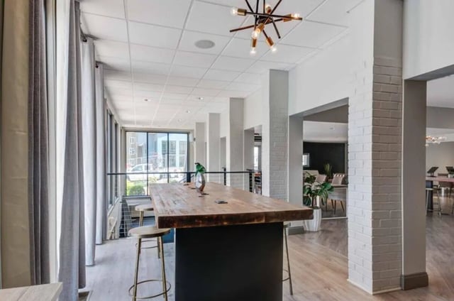 Wooden table with stools and large windows communal area at Terrace View in Blacksburg Student Accommodation