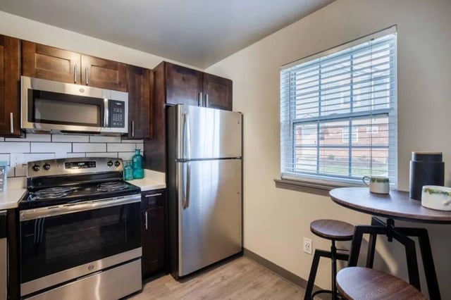 Stainless steel appliances dark wood cabinets small table kitchen at Terrace View in Blacksburg Student Accommodation