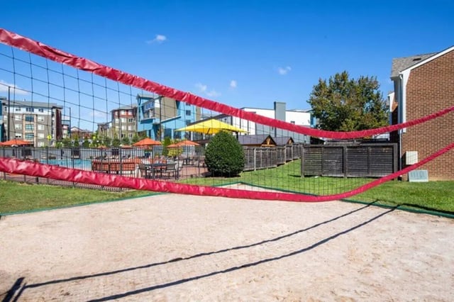 Volleyball court with apartment buildings and pool recreation area at Terrace View in Blacksburg Student Accommodation