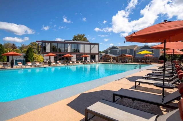 Large pool lounge chairs umbrellas exterior at Terrace View in Blacksburg Student Accommodation
