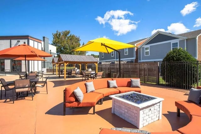 Orange couch fire pit umbrellas outdoor seating area at Terrace View in Blacksburg Student Accommodation