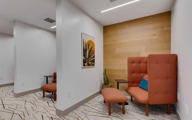 Two orange chairs artwork and wood paneling common area at Nine 20 Tempe in Tempe Student Accommodation