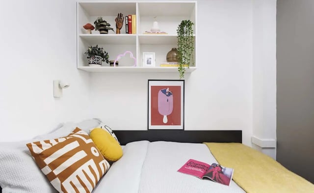 Bed with cushions and shelf bedroom at New Medlock House in Manchester Student Accommodation