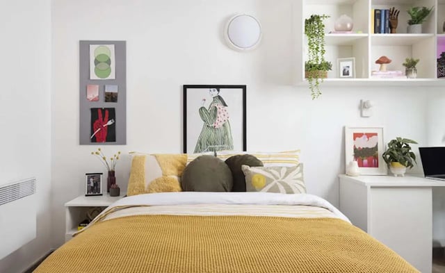 Bed with pillows artwork and shelves bedroom at New Medlock House in Manchester Student Accommodation