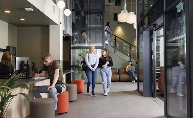 Students at reception and lounge area communal space at New Medlock House in Manchester Student Accommodation