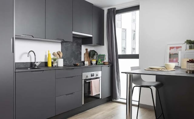 Modern grey kitchen with oven dining table kitchen at Parkway Gate in Manchester Student Accommodation