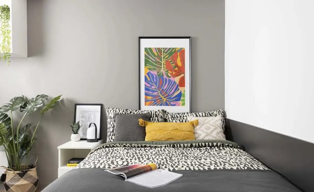 Bed with colorful artwork and plants bedroom at Parkway Gate in Manchester Student Accommodation