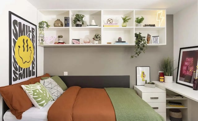 Bed with patterned pillows and shelves bedroom at Parkway Gate in Manchester Student Accommodation