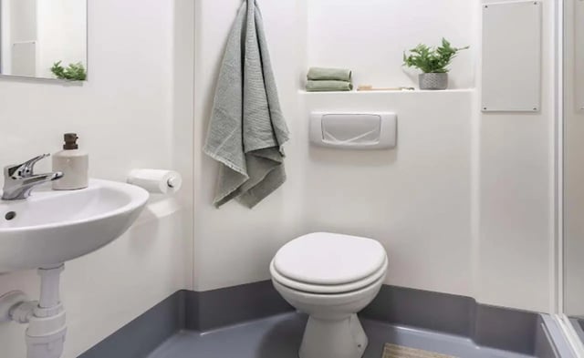 Toilet sink towel plant and toiletries bathroom at Piccadilly Point in Manchester Student Accommodation