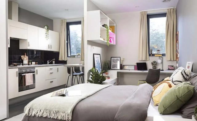 Bed kitchen desk area and bed bedroom studio at Piccadilly Point in Manchester Student Accommodation