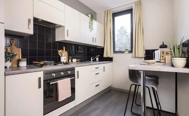 Cream cabinets oven sink table with stools kitchen at Piccadilly Point in Manchester Student Accommodation