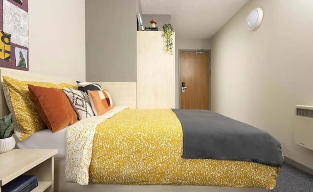 Bed with colorful pillows and bedside table bedroom at Piccadilly Point in Manchester Student Accommodation