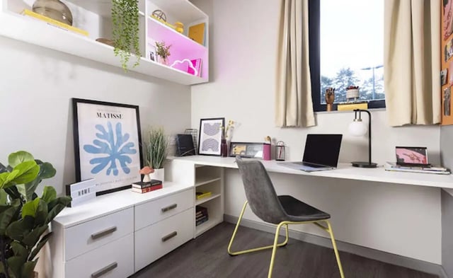 Desk with laptop and artwork study area at Piccadilly Point in Manchester Student Accommodation