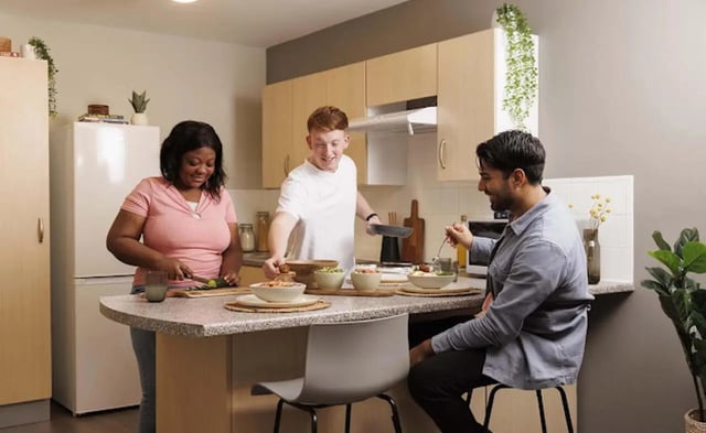 Students preparing and eating food in kitchen kitchen at Piccadilly Point in Manchester Student Accommodation