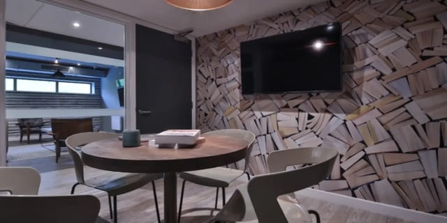 Round table chairs TV book wallpaper common area at One & Two Victoria Point in Manchester Student Accommodation