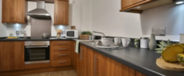 Wood cabinets oven microwave sink and fruit kitchen at One & Two Victoria Point in Manchester Student Accommodation